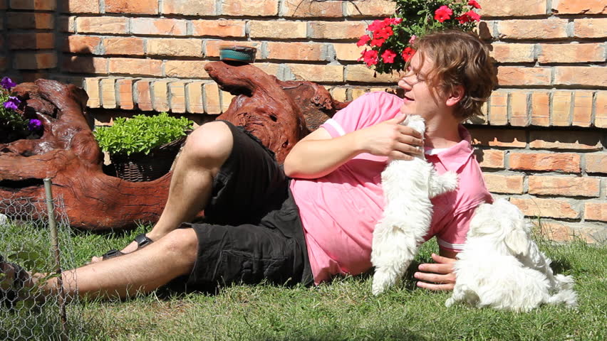 Happy man playing with a maltese puppy