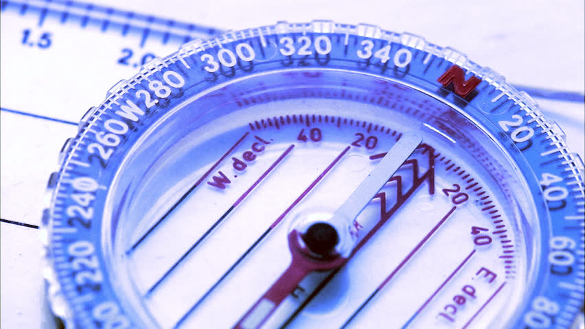A compass needle turning, close-up.