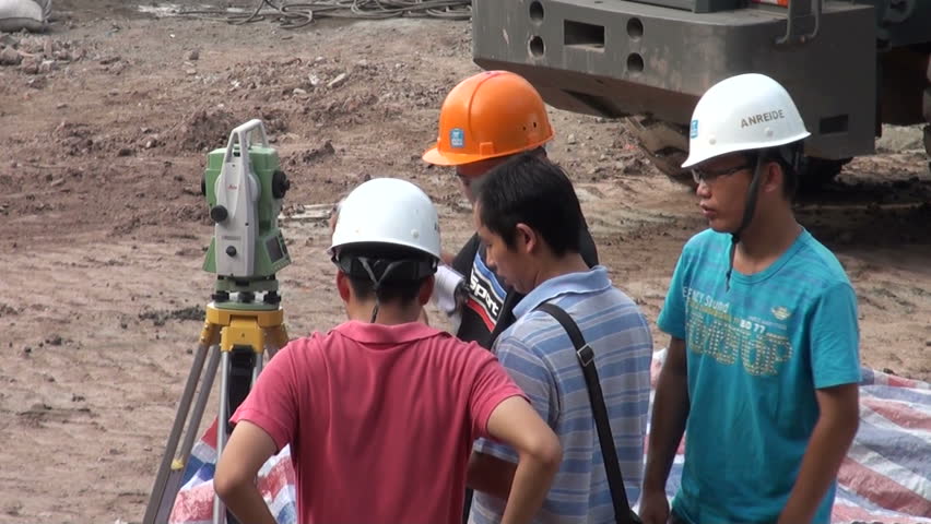 CHONGQING - AUGUST 17 2010: Chinese engineers are measuring the size of a construction ground in Chongqing, China

