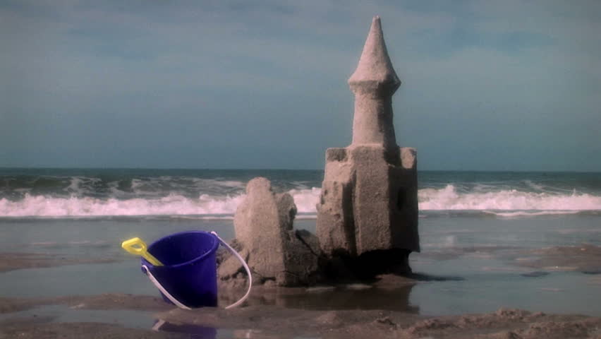 Great beach and ocean shot with sand castle that crumbles with the tide. Nice color toning. South Carolina.