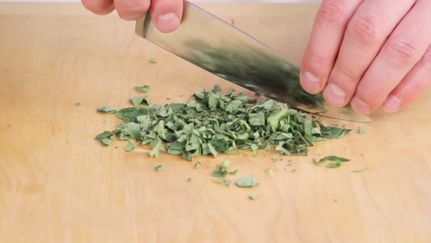 Finely chopping oregano leaves