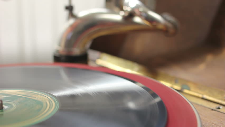 Hand putting vintage gramophone in starting position