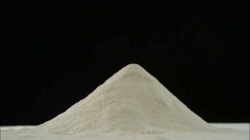Man's hand smashes into a pile of flour