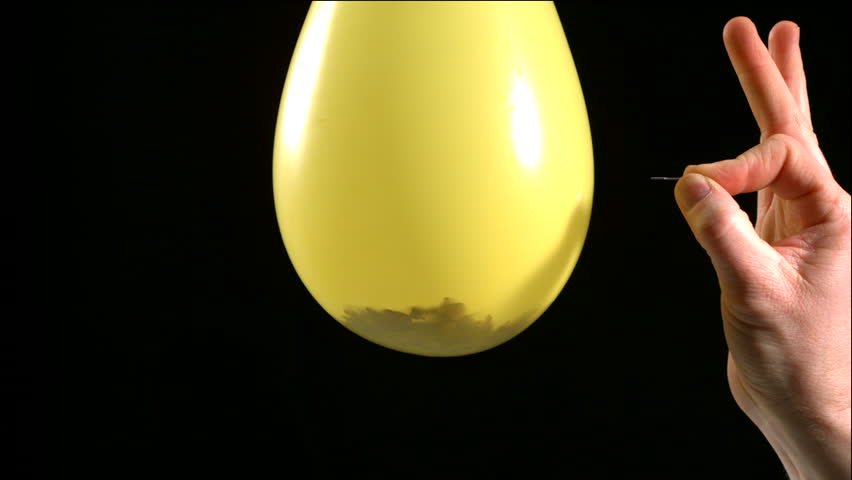 Man popping yellow balloon filled with confetti