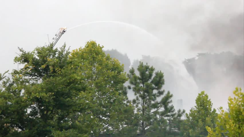 Ladder Mounted Water Cannon Above Trees Sprays Water On Large Outdoor Fire