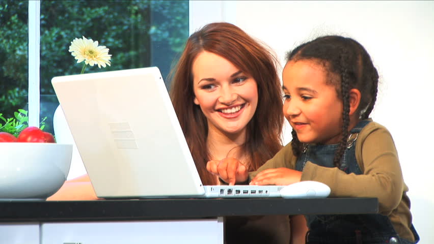 Beautiful brunette girl & adorable child using laptop computer