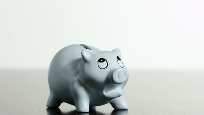 Studio shot of 10 kg weight falling on piggybank