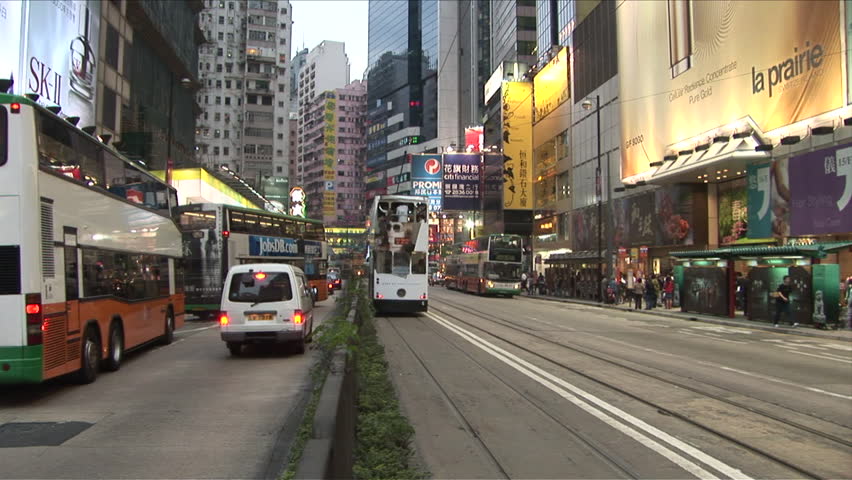 Hong Kong, China - CIRCA April, 2007: Buses and trams drive away from the camera on both sides