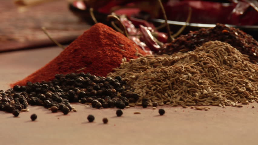 pan right to left of mexican chef using mocaljete to crush peppers