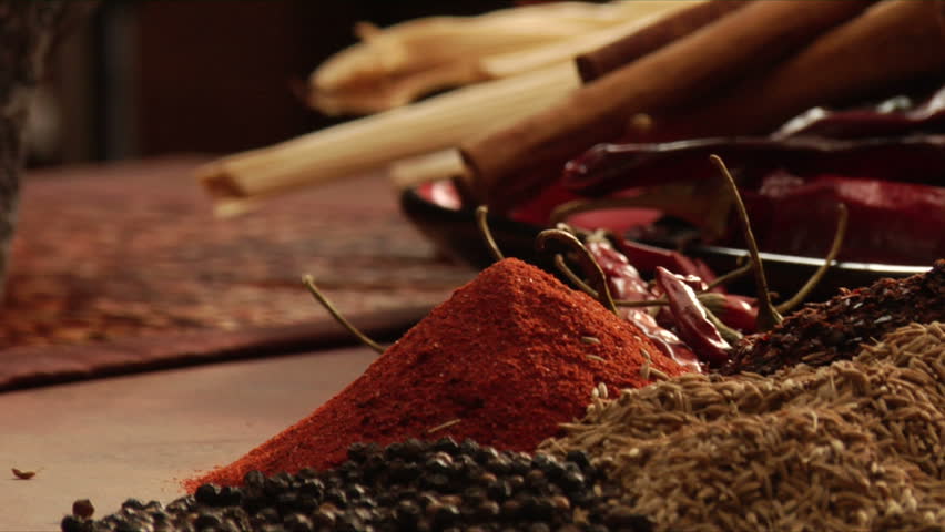 pan left to right of mexican chef using mocaljete to crush peppers
