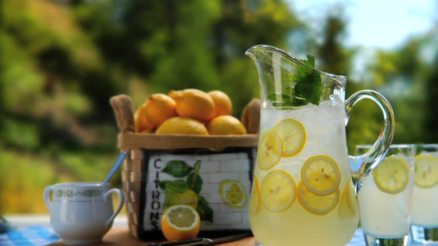Pitcher of lemonade and glasses on table outside