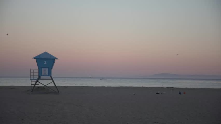 Life Guard Stand in California at Sunset in Slow Motion with Birds Flying Through