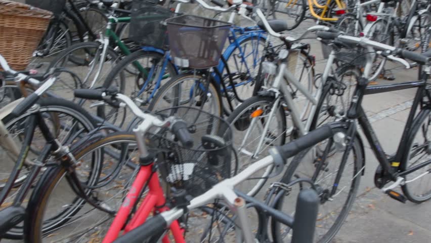 Many bicycles with baskets on parking, closeup view in motion