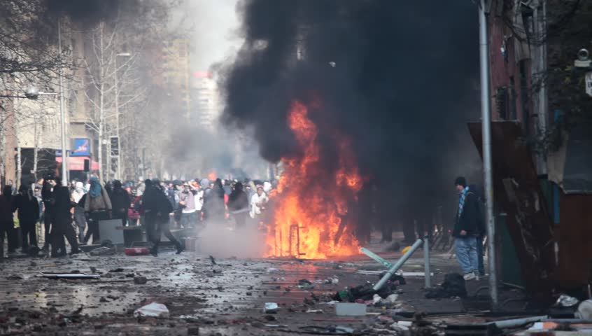 SANTIAGO, CHILE - AUGUST 9: Car overturned and burned and street damage caused during a student strike on August 9, 2011 in Santiago, Chile.