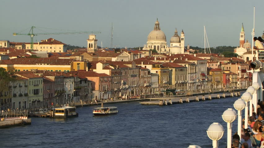 Venice, Italy, May 11, 2011: People looking from a cruise ship across venetian roof tops. Tourist levy by Italian government sees tourists paying more to visit Venice.