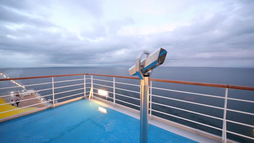 empty main deck with viewing field-glasses and sea with heavy clouds in distance