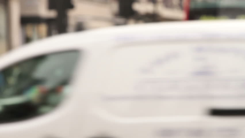 Blurred and unrecognizable buses, taxis and pedestrians at Oxford Circus, London