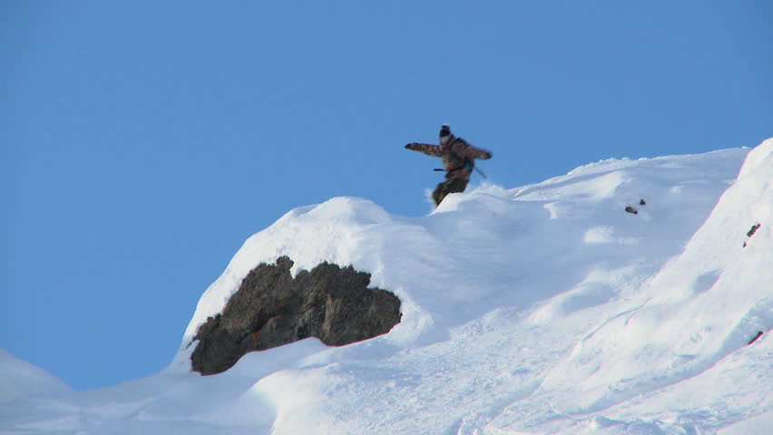 Male snowboarder carving through steep terrain