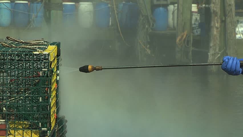 NEWPORT, RHODE ISLAND - CIRCA JULY 2010: Fisherman pressure washing lobster traps 