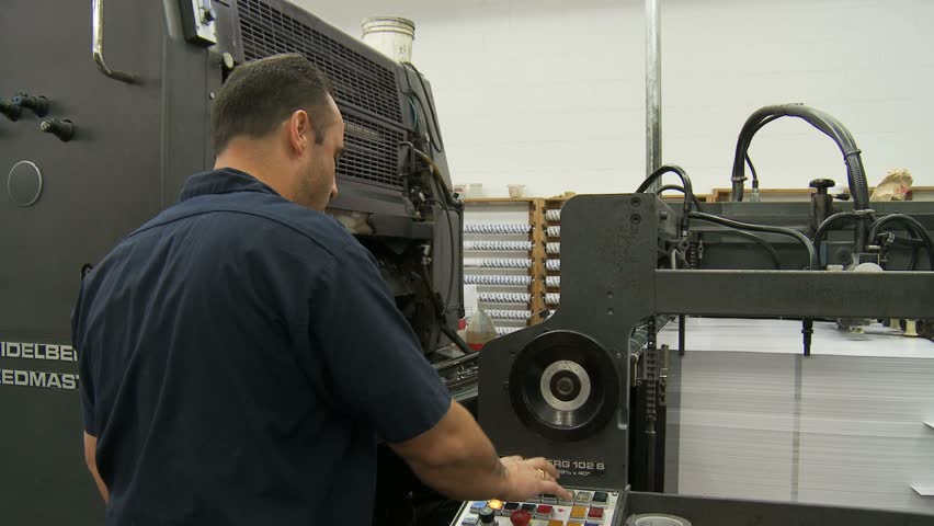 NEW ENGLAND, USA - CIRCA FEBRUARY 2009: Stack of paper being fed into commercial printing press 