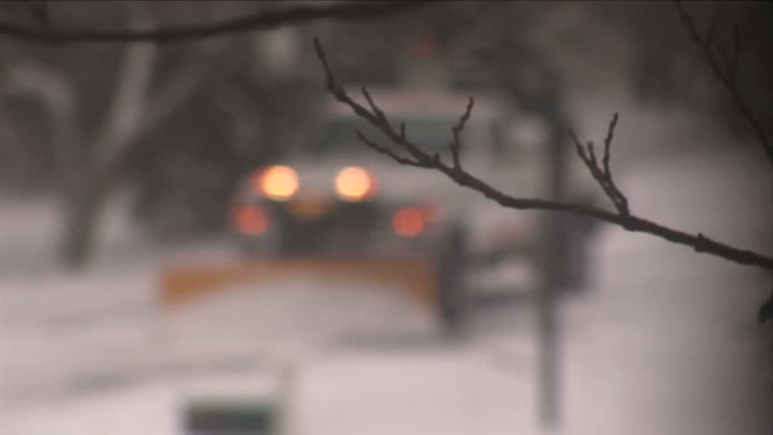 NEW ENGLAND - CIRCA JANUARY 2006: Pickup truck snowplowing residential street in snowstorm