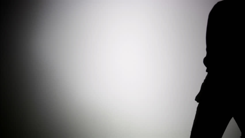 The silhouette of a construction worker climbing a ladder.