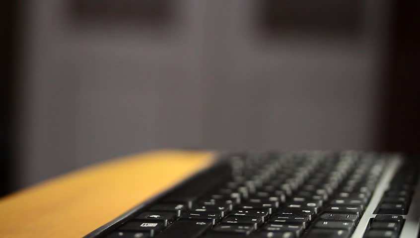 Male hands type on keyboard close up