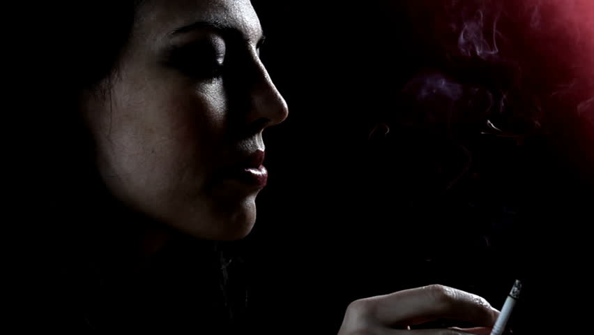 Woman smokes in the dark