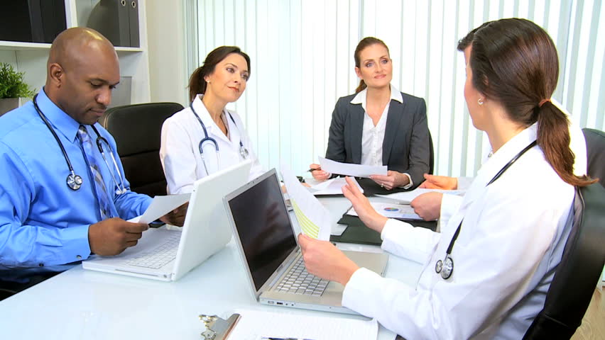 Female Caucasian financial advisor meeting medical team executives in hospital boardroom