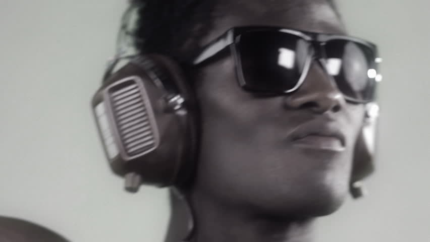 african cool guy dancing with headphones and glasses with a silver style