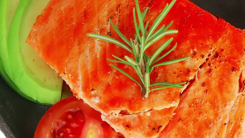 food: grilled salmon on iron pan over wooden plate isolated on white background