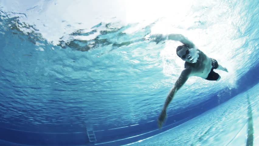 underwater view of professional crawl swimmer in outdoor swimming pool in summer