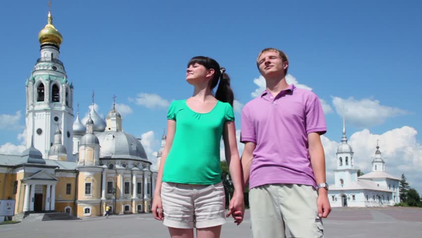 Young couple near Holy Resurrection cathedral, Alexander Nevsky church on Kremlin square in Vologda, Russia