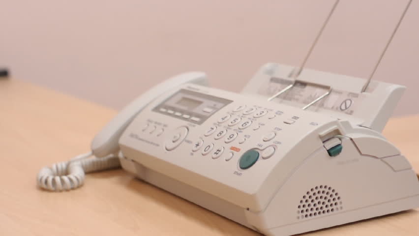 Man in office turns on speaker-phone on telephone