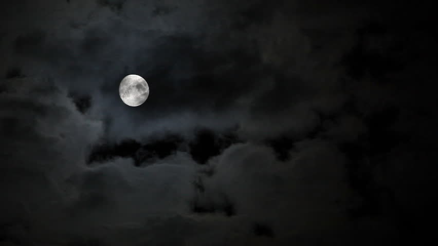 Full moon behind clouds at night