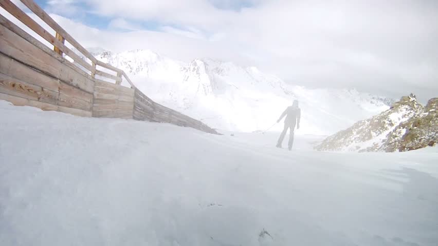 Snowboarder very quickly moves down on ski route against ridges