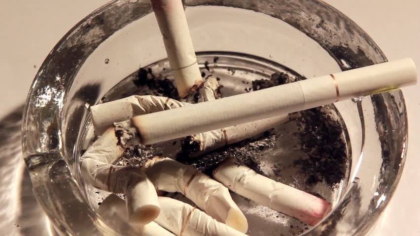 A burning cigarette in an ashtray -time lapse