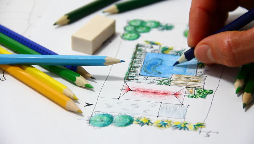 Man sketching on landscape architectural drawing.