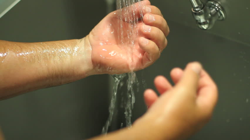 Doctor washes hands in preparation for surgery.