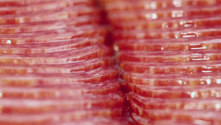 Vacuum packed slices of salami sausage circling closeup