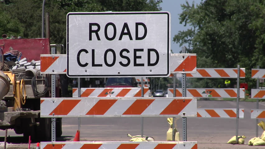 Two shots of same scene (one medium, one wide) showing a road closed due to construction. Features "Road closed" signs.