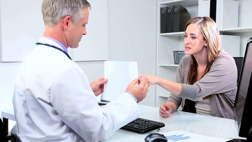 Female pharmaceutical saleswoman meeting male doctor in his office