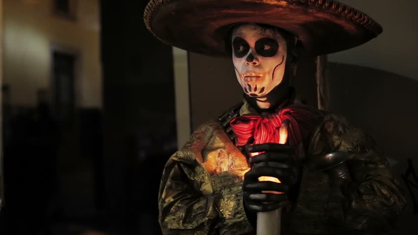 Artist with face painted like skull in Mexican Holiday Day of Dead