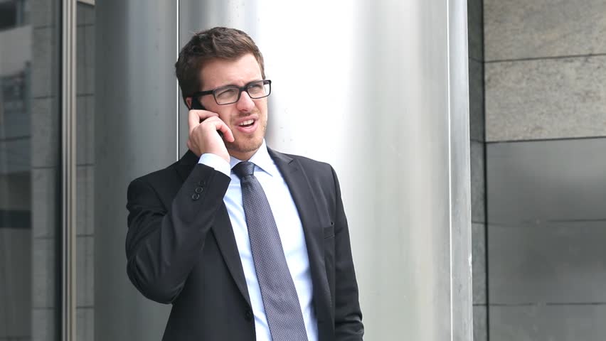 Handsome businessman talking at phone outdoor in the city