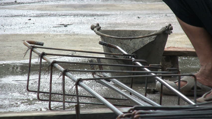 An Asian man working with rebar steel on a construction job site in Bangkok, Thailand.