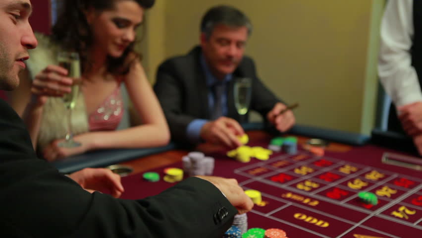 People placing bets at craps table in casino