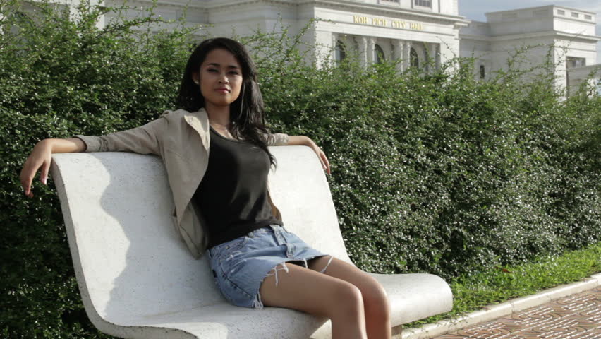 Cambodian girl sitting park bench