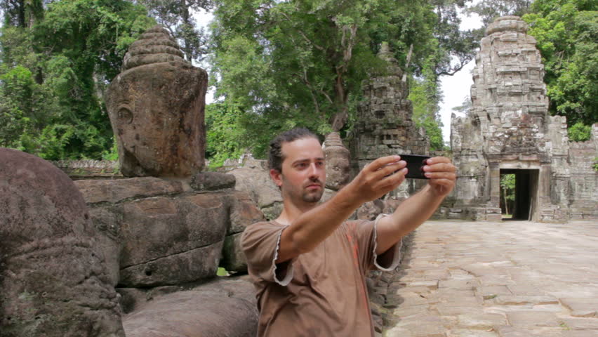 a lone visitor takes own picture in preah khan temple, Angkor