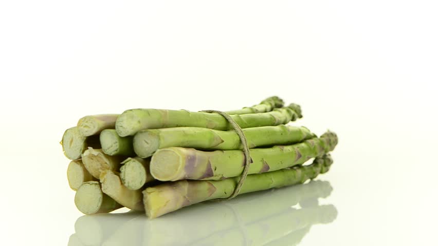 Rotating fresh green asparagus isolated on white background.
