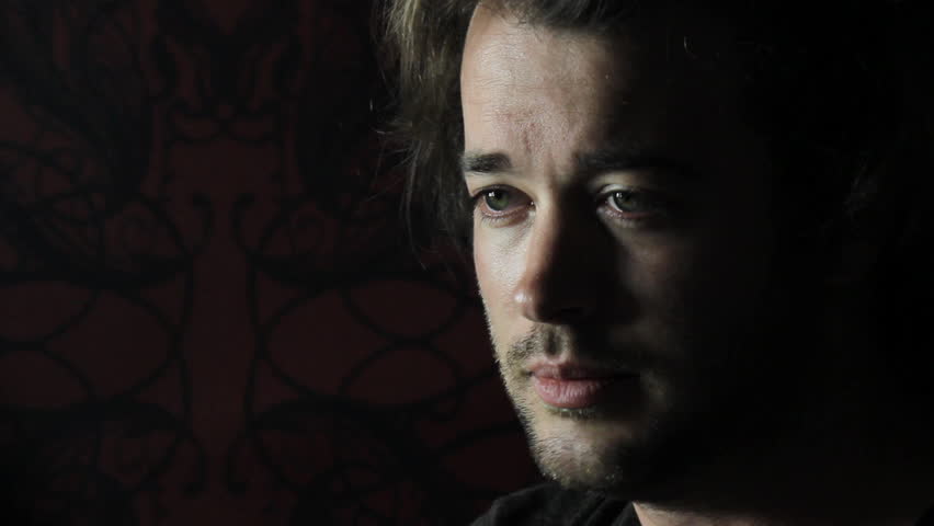 Man sits in dark room smokes - Close-up